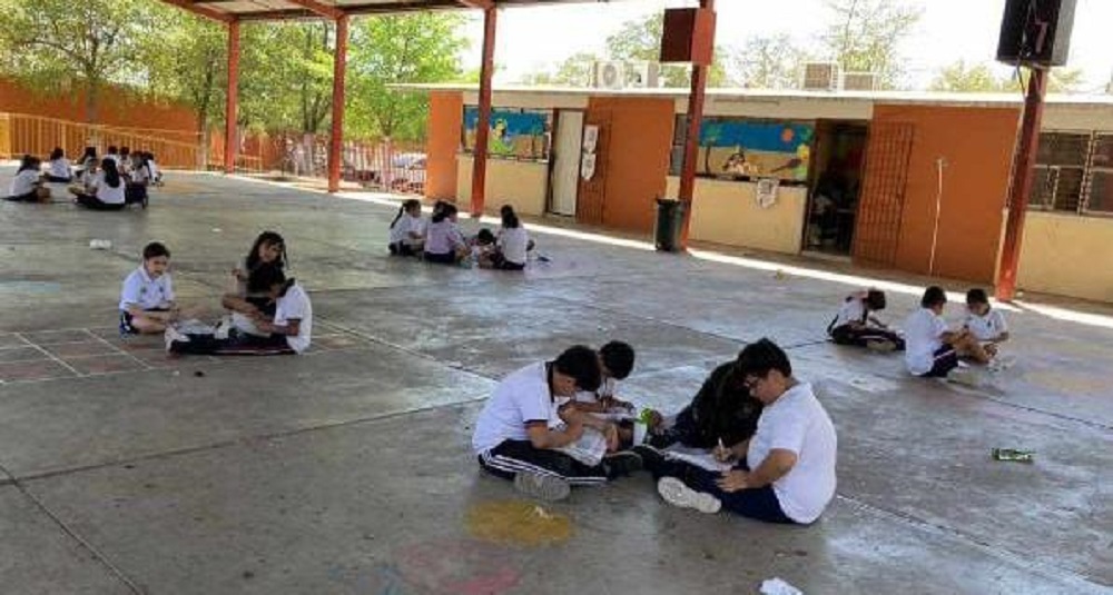(FOTO) En el piso, bajo la techumbre, toman clases niños de la escuela Margarita Maza de Juárez en Culiacán
