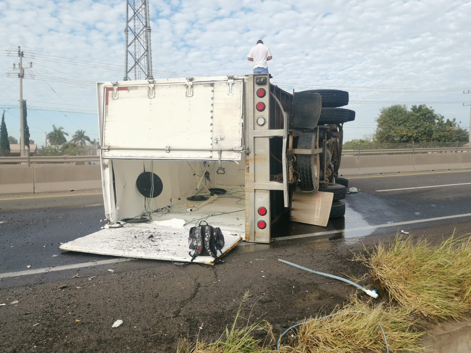 Operador de un tractocamión queda volcado sobre el puente a desnivel en Juan José Ríos, Guasave