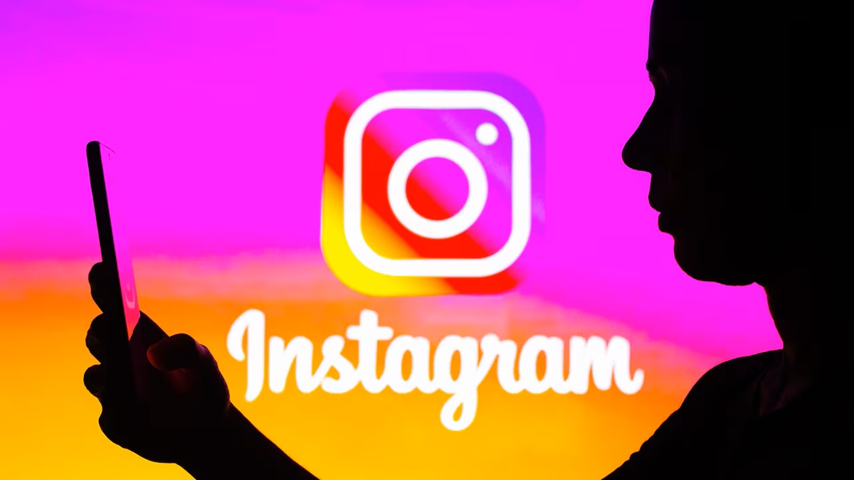 Perfil de persona usando celular y al fondo logotipo de Instagram