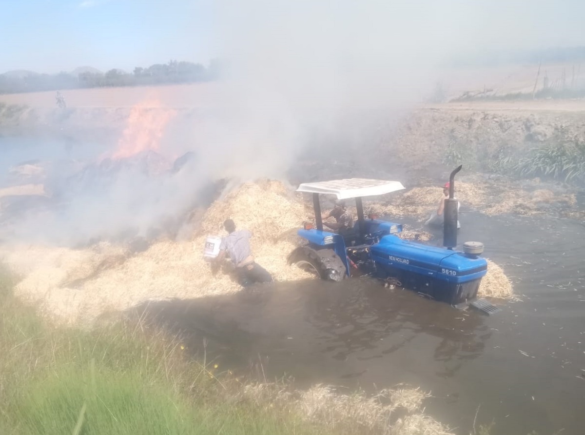 Se incendia tractor cargado de pacas luego de caer a canal de riego en San José, Ahome