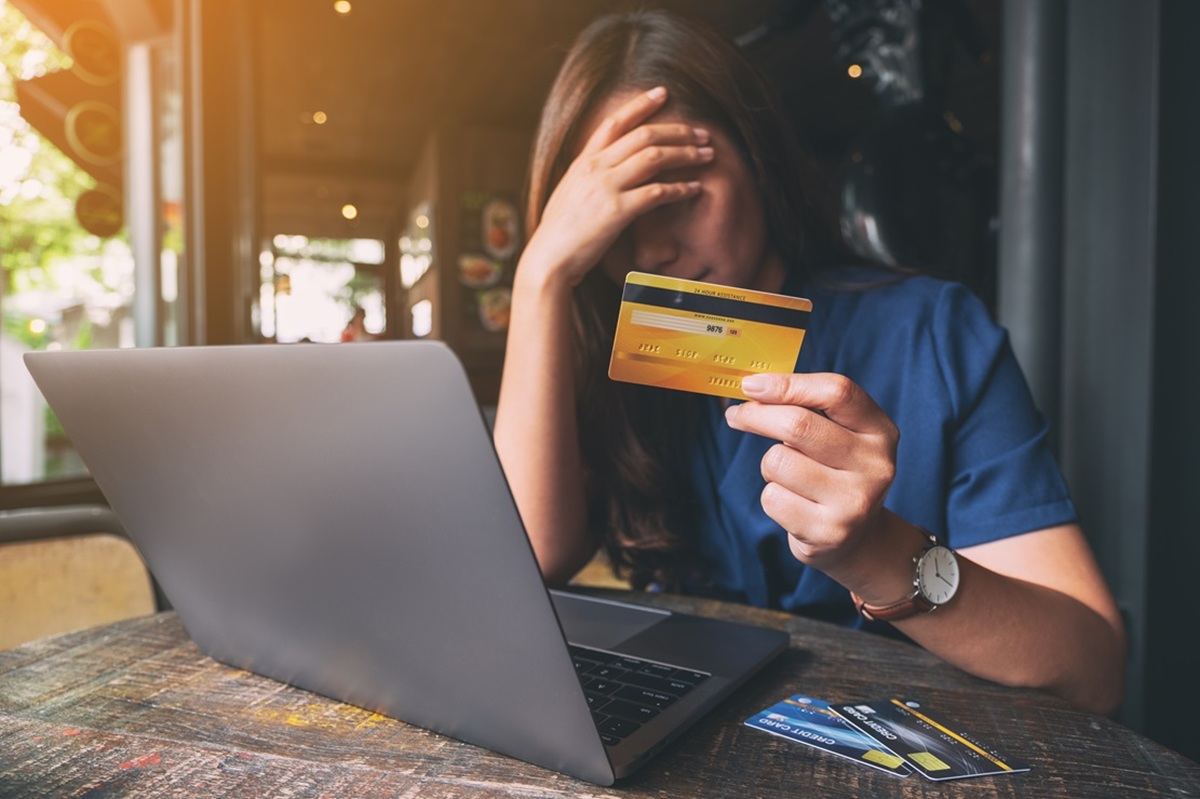 Joven mujer con tarjeta de crédito y una laptop