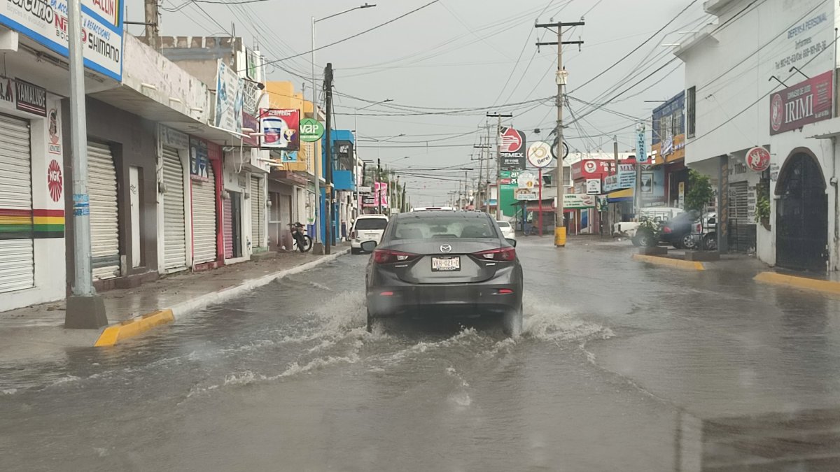 vehículo circulando por una calle con agua en lluvia