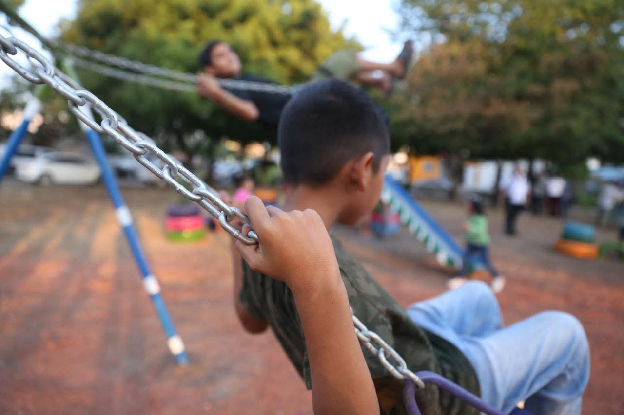Niño jugando en columpios