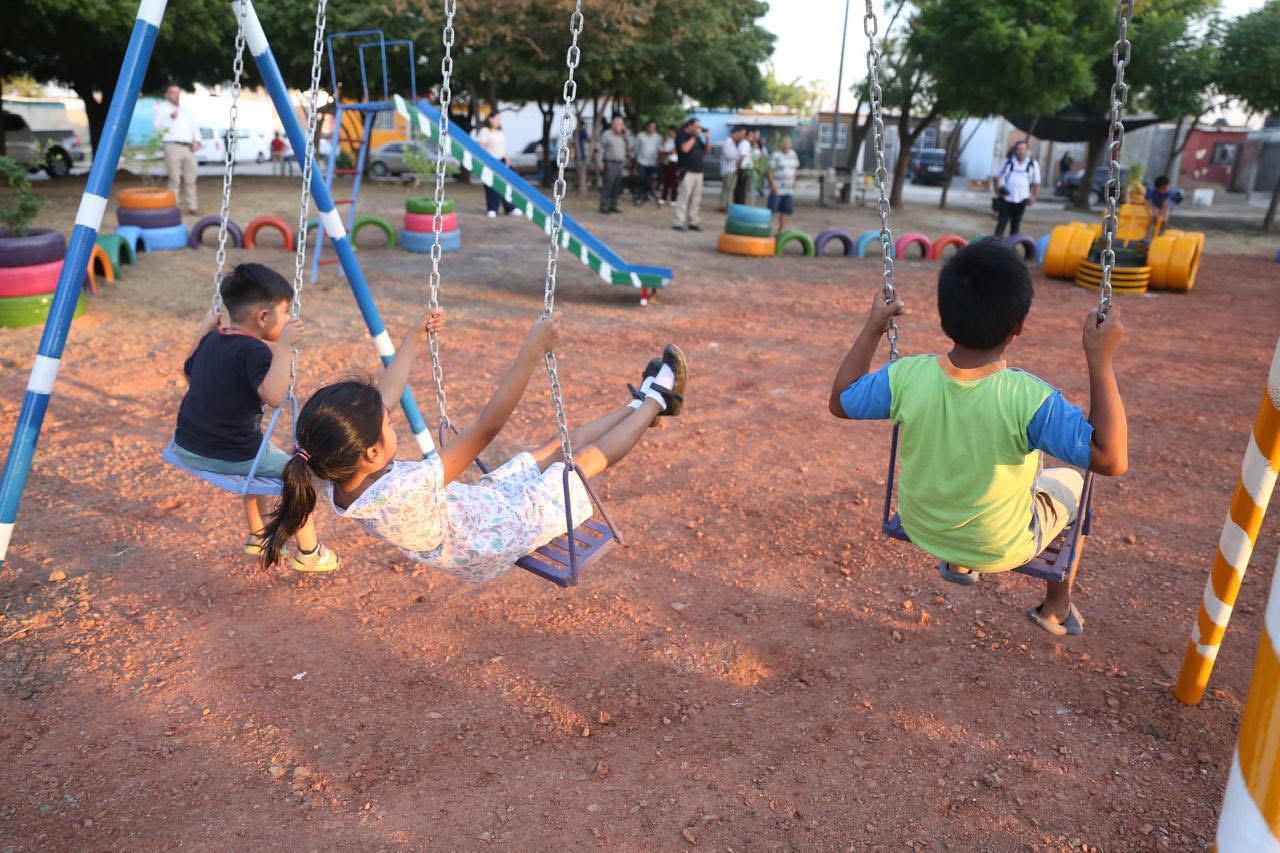 Niños jugando en columpios