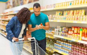 Dos personas comprueban la caducidad de un producto en un supermercados