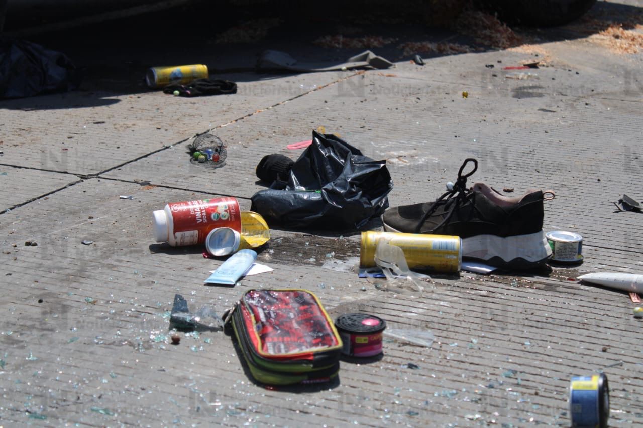 zapatos, lapicera y latas de cerveza tirados en la calle