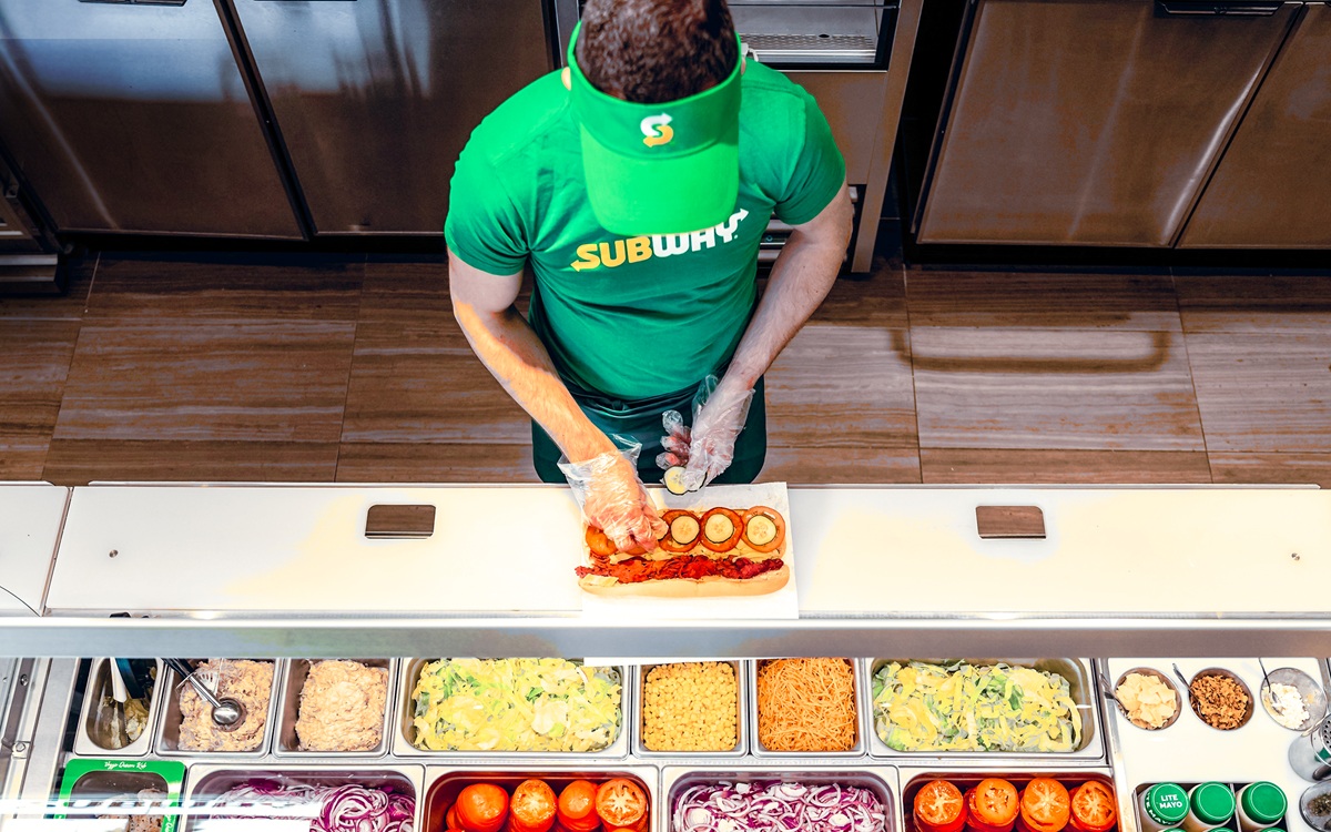 Empleado en barra de ingredientes de Subway