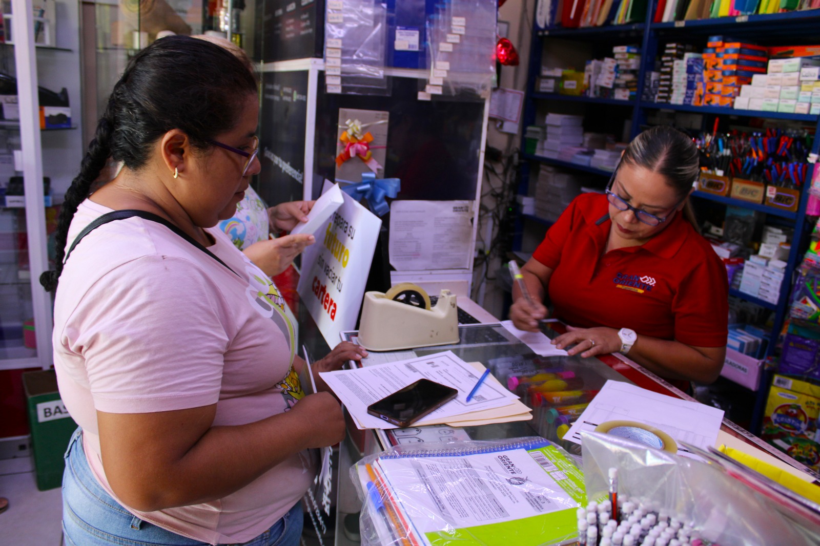 Madre de familia realizando canje de paquete de útiles escolares
