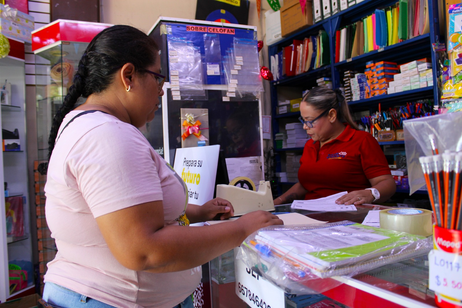 Madre de familia realizando canje de paquete de útiles escolares