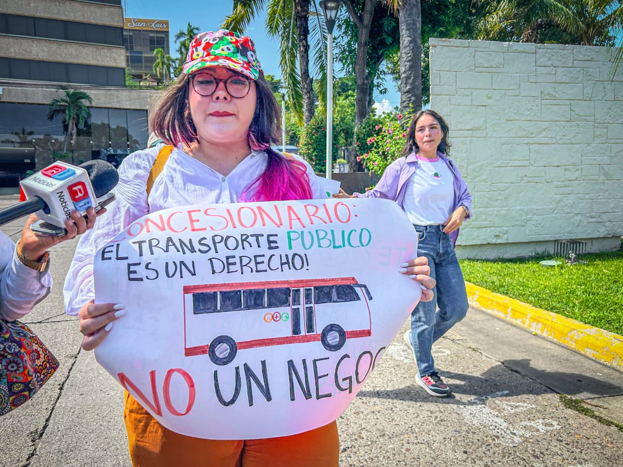 Delilah Barajas sostiene una Pancarta donde se lee: Concesionario, el transporte público es un derecho, no un negocio