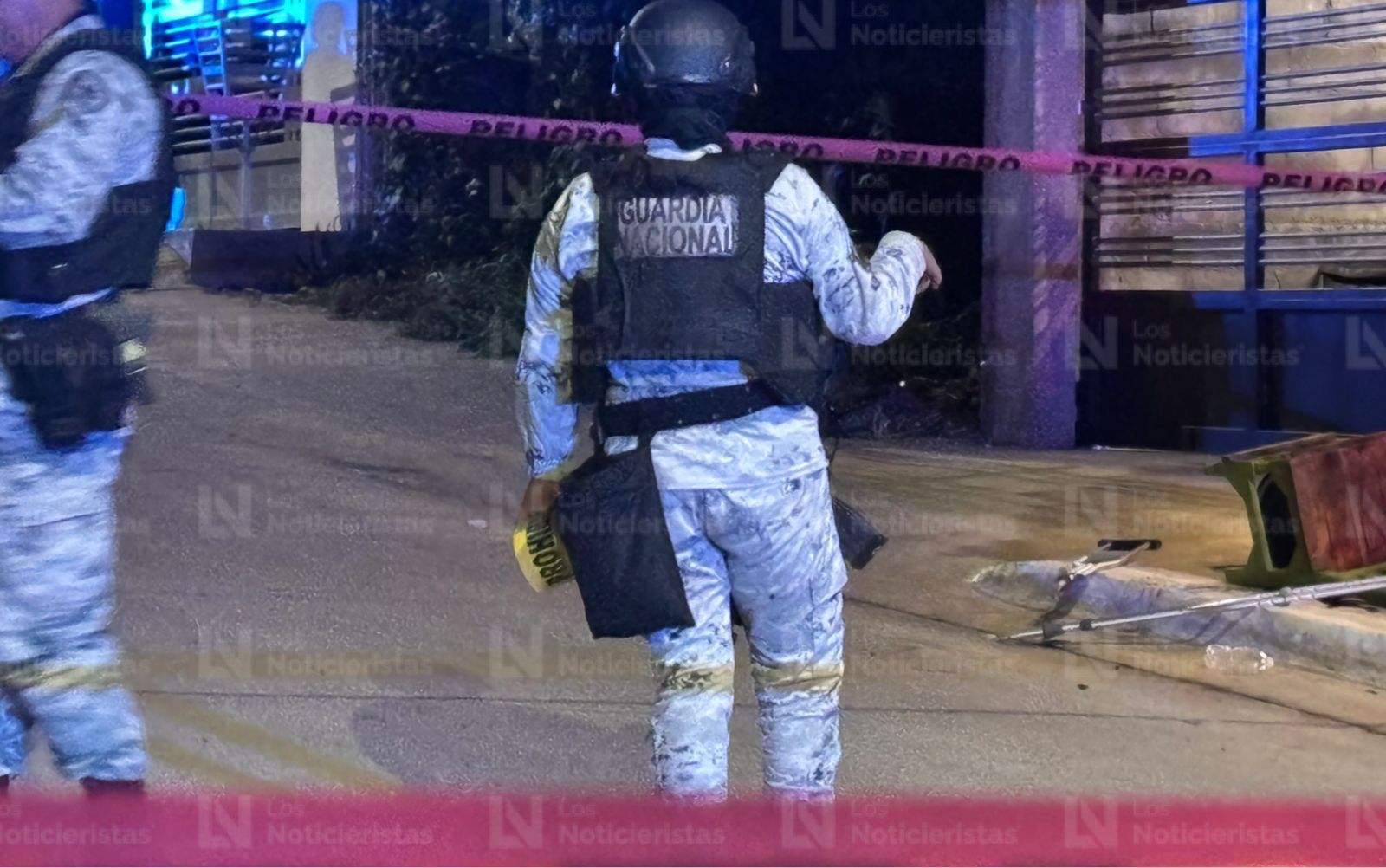 Elementos de la Guardia Nacional resguardan el lugar donde un hombre en muletas fue ejecutado, en Culiacán