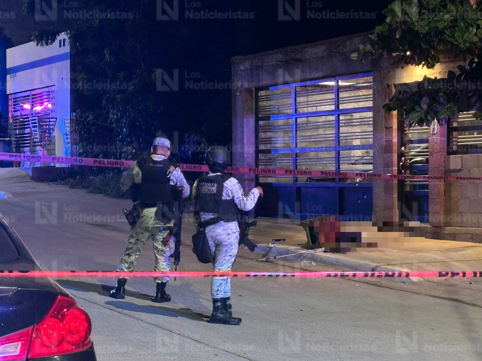 Elementos de la Guardia Nacional resguardan el lugar donde un hombre en muletas fue ejecutado, en Culiacán
