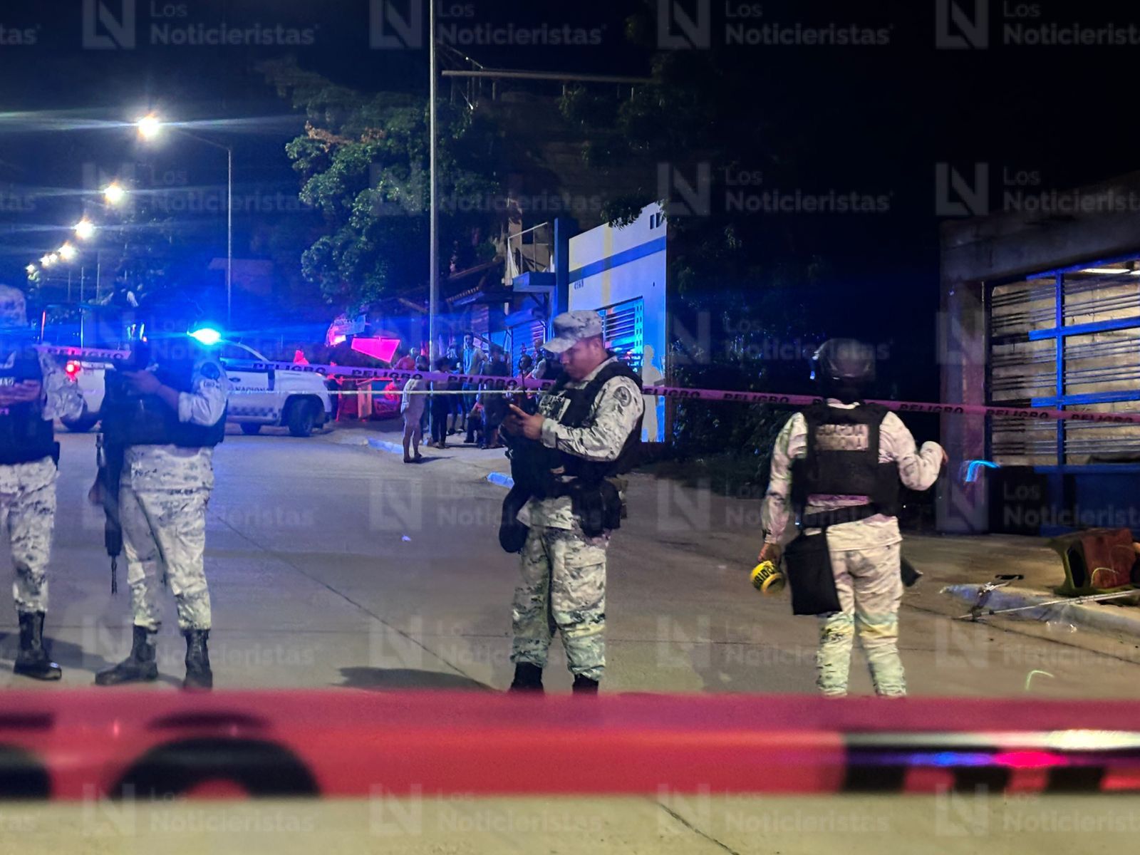Elementos de la Guardia Nacional resguardan el lugar donde un hombre en muletas fue ejecutado, en Culiacán