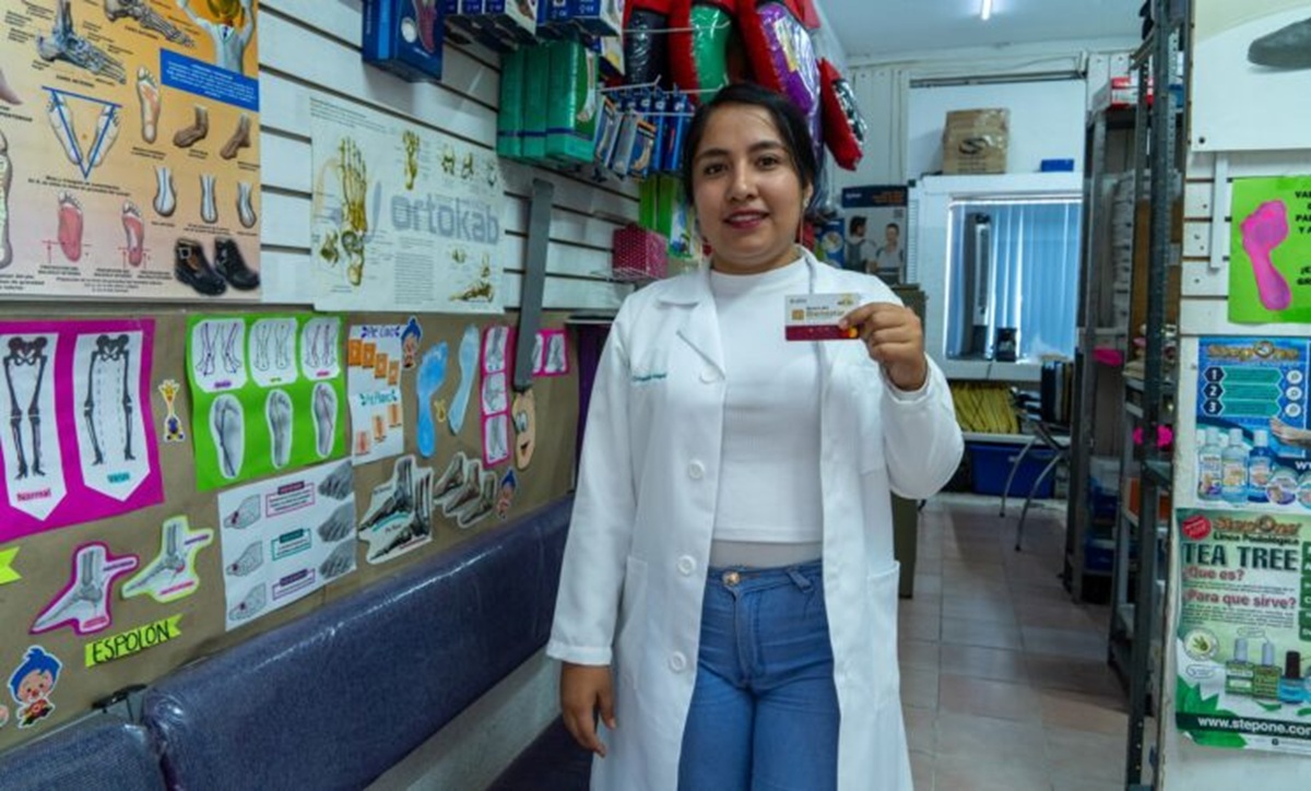 Joven mujer beneficiaria de Jóvenes Construyendo el Futuro con su tarjeta del Bienestar