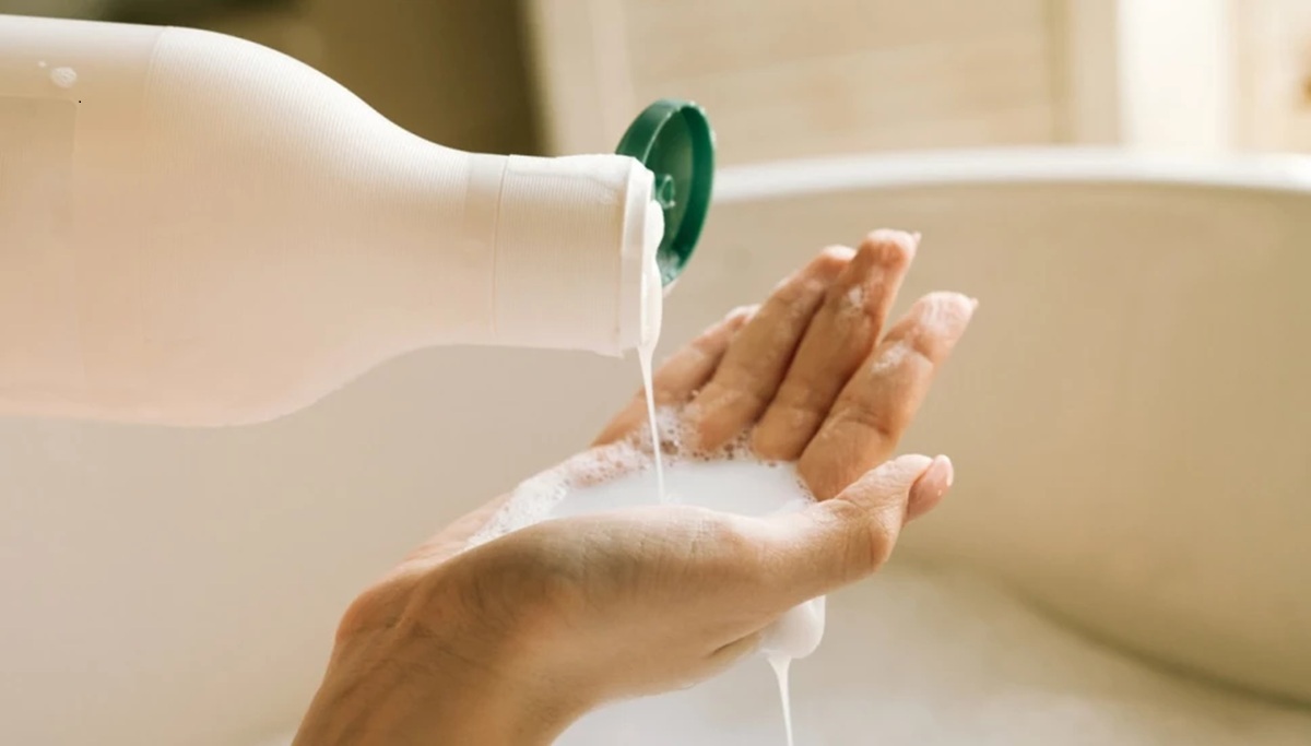 Manos de mujer, sirviéndose shampoo