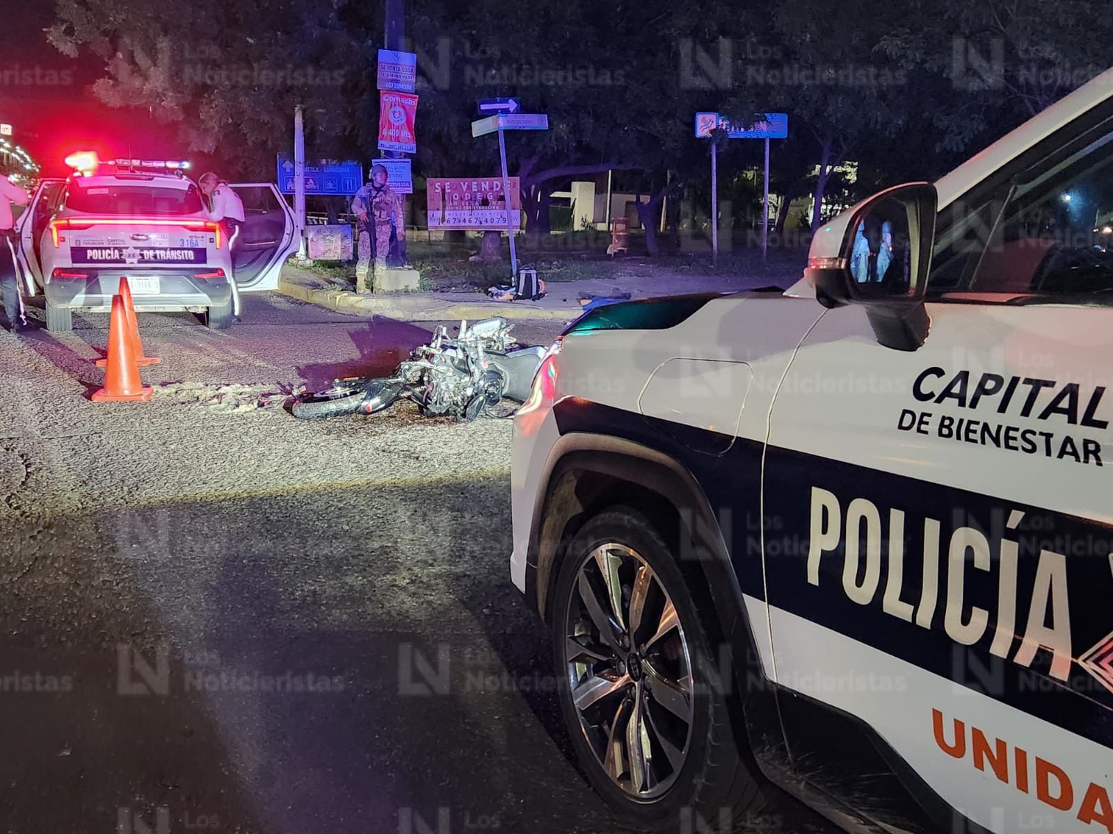 Policías resguardan el lugar donde murió un motociclista tras impactarse contra camioneta, en Culiacán