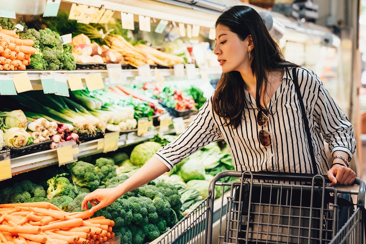 Joven mujer seleccionando verduras en el súper
