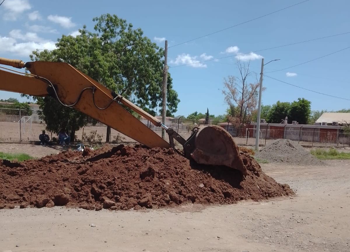 máquina retroexcavadora realiza trabajos de reparación de drenajes taponados