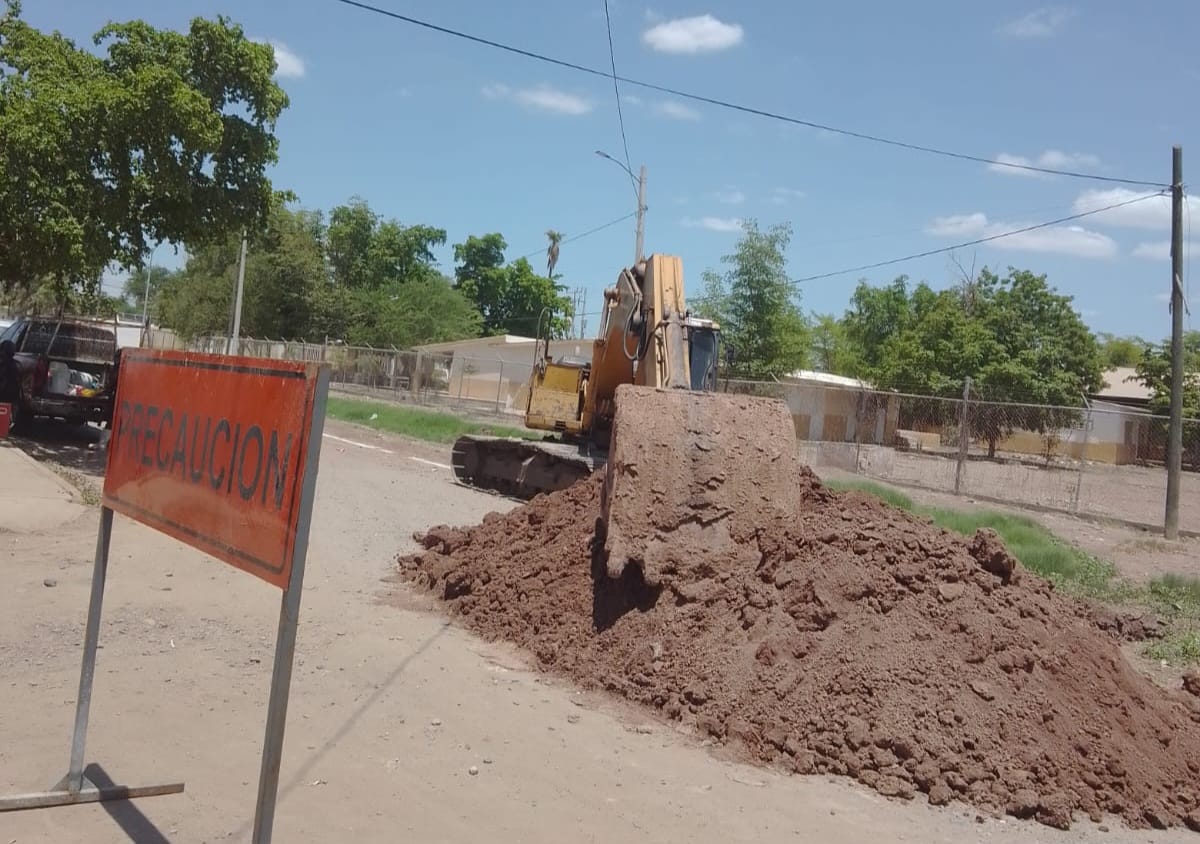 máquina retroexcavadora realiza trabajos de reparación de drenajes taponados