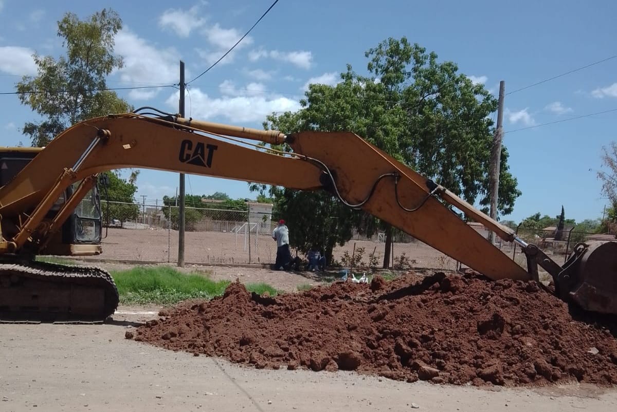 máquina retroexcavadora realiza trabajos de reparación de drenajes taponados