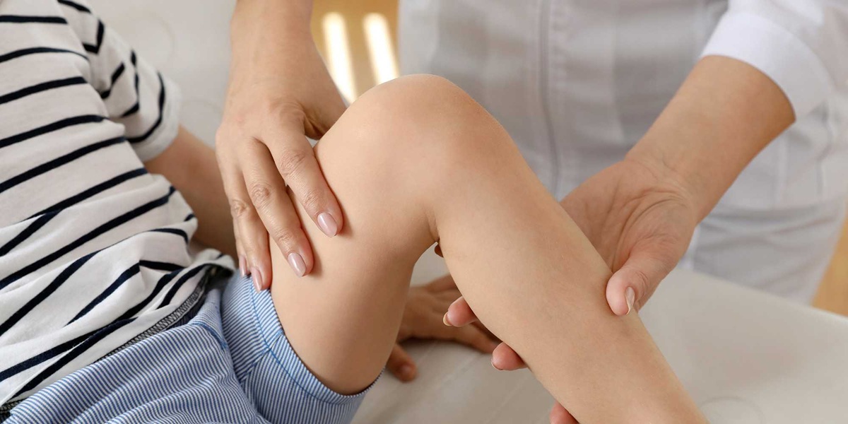 Dolores del crecimiento. Doctora revisando la rodilla de un niño