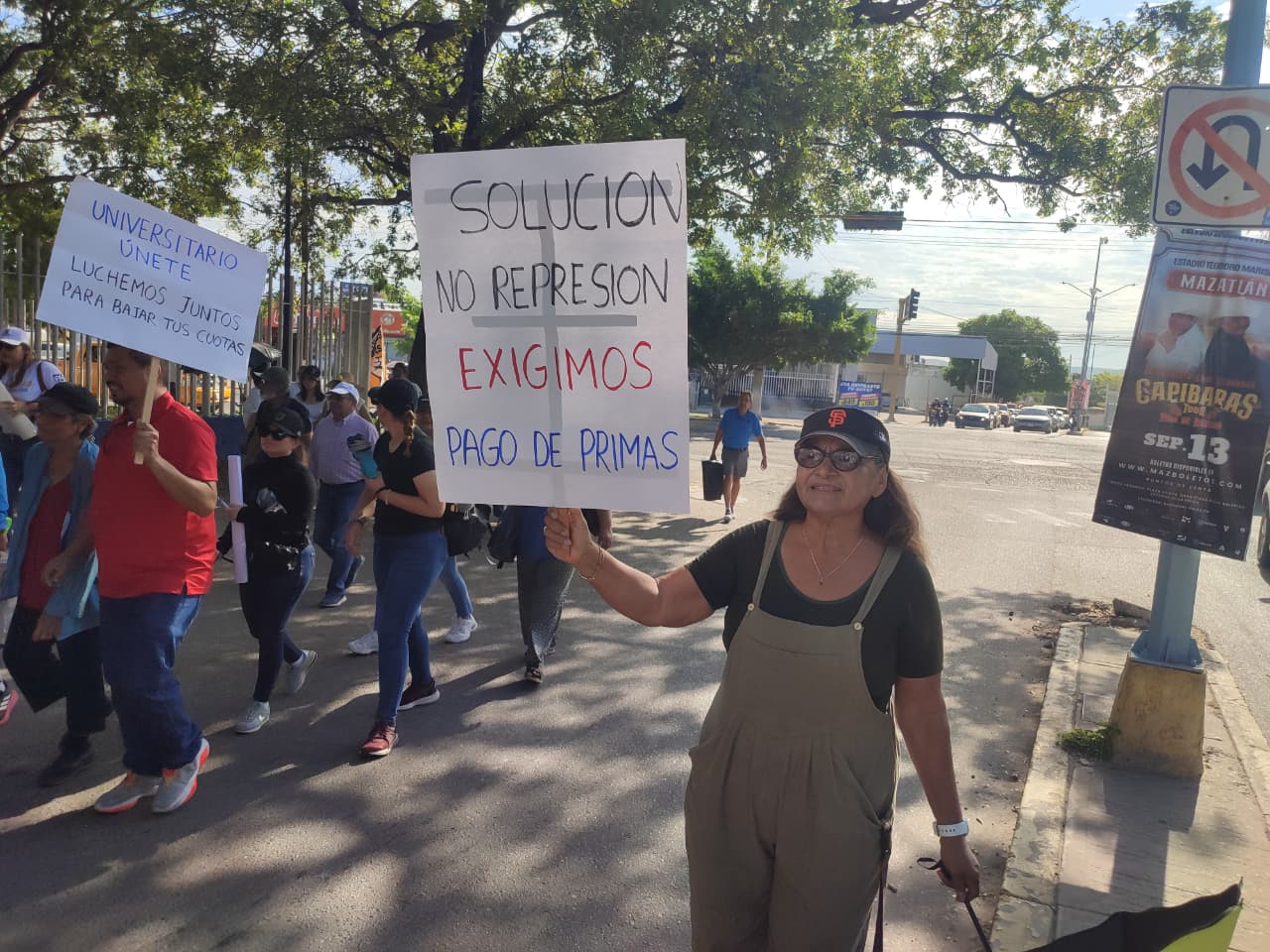 Persona sostiene cartulina donde se lee: Solución no represión, exigimos pago de primas