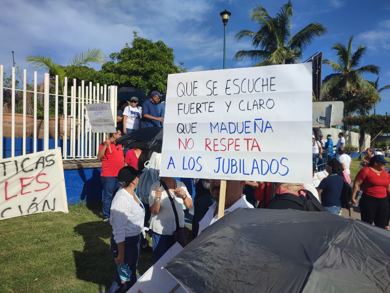 Persona sostiene cartulina donde se lee: Que se escuche fuerte y claro que Madueña no respeta a los jubilados