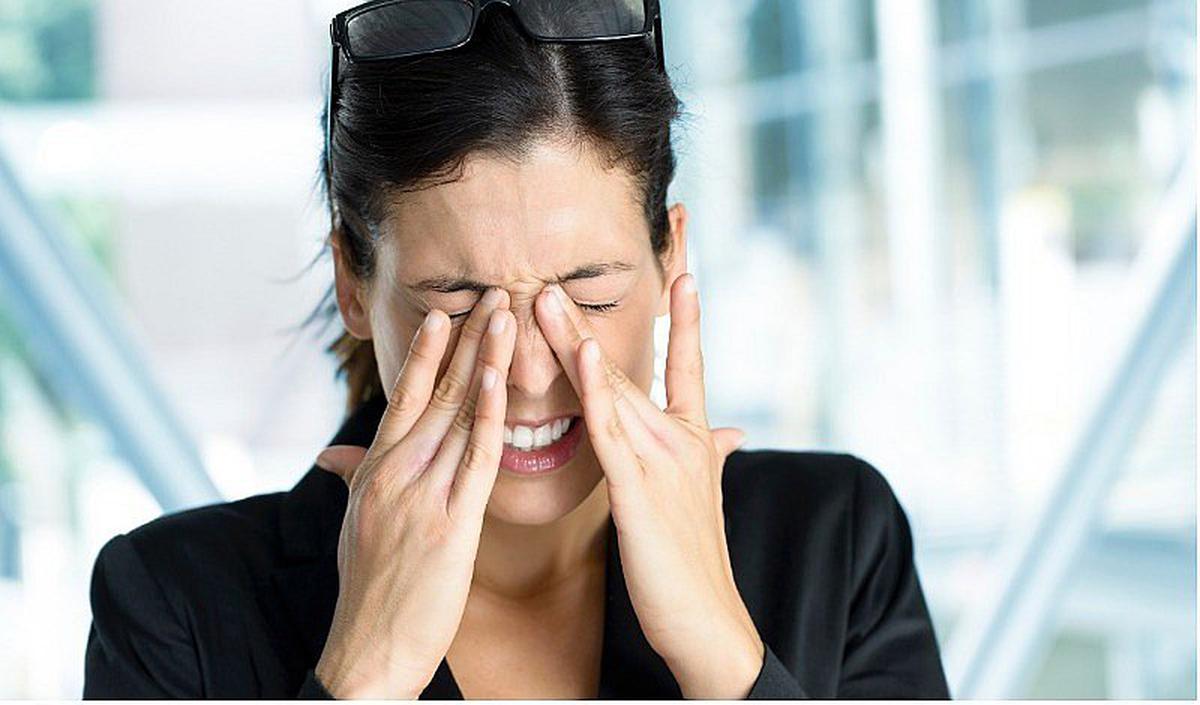Mujer tallándose los ojos por el Síndrome Visual Informático