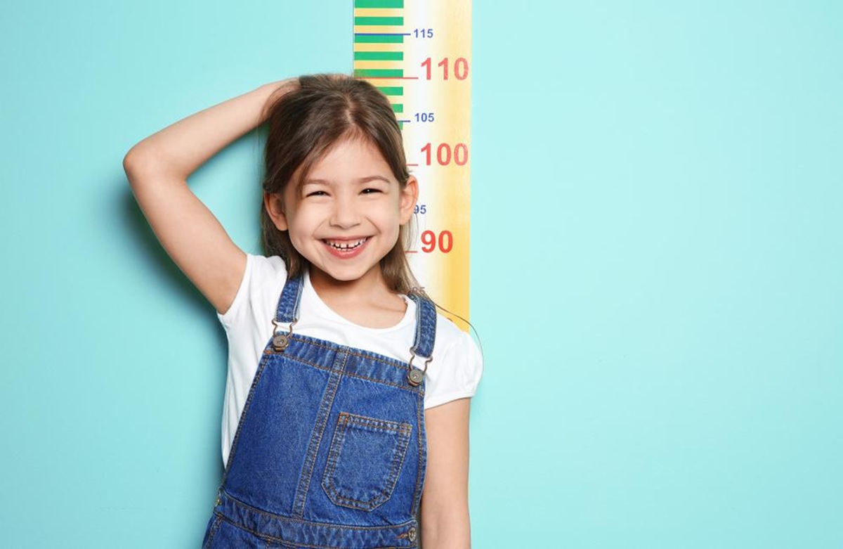 Niña midiéndose la estatura y su crecimiento