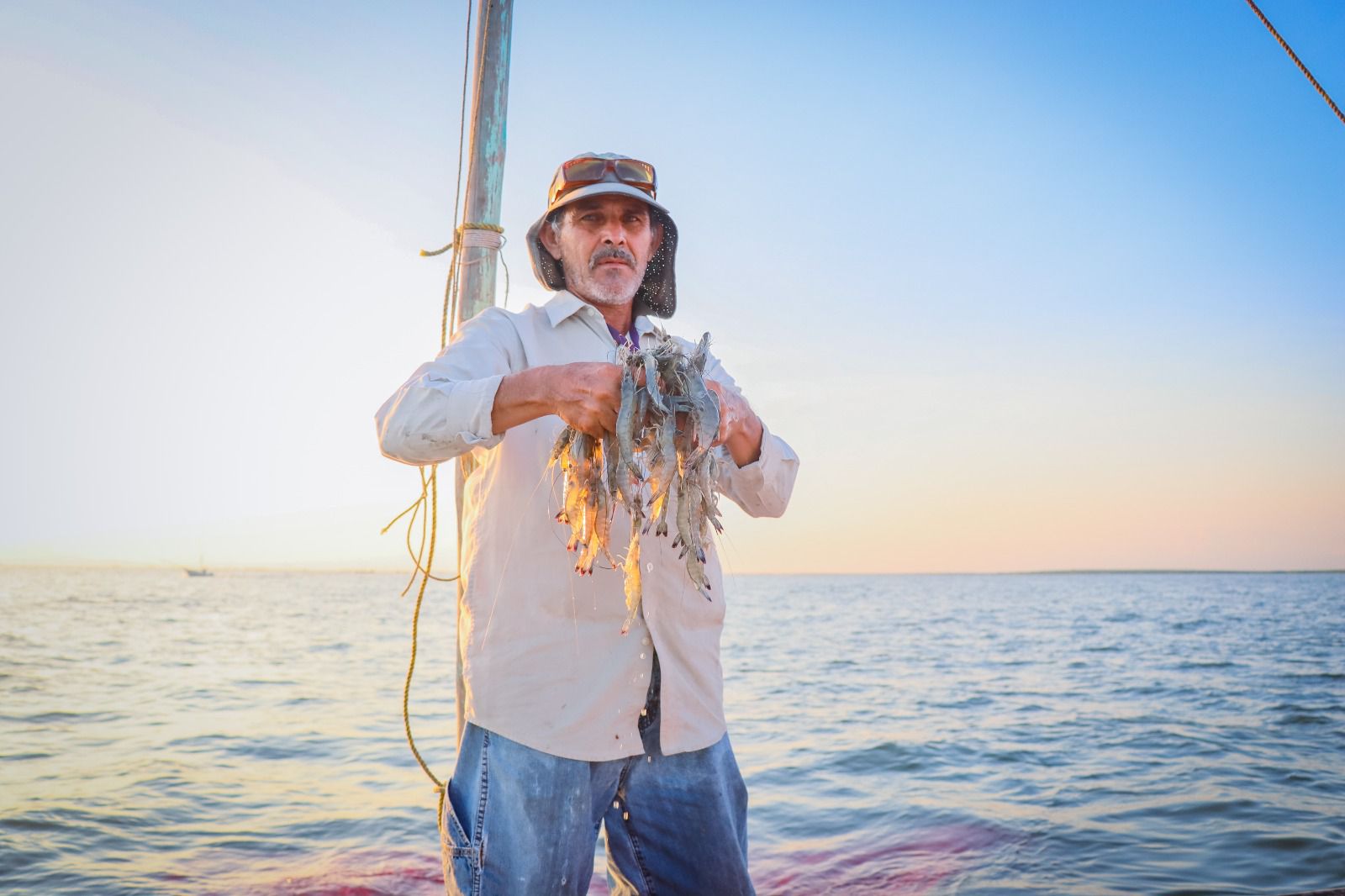 Pescador muestra su captura de camarón