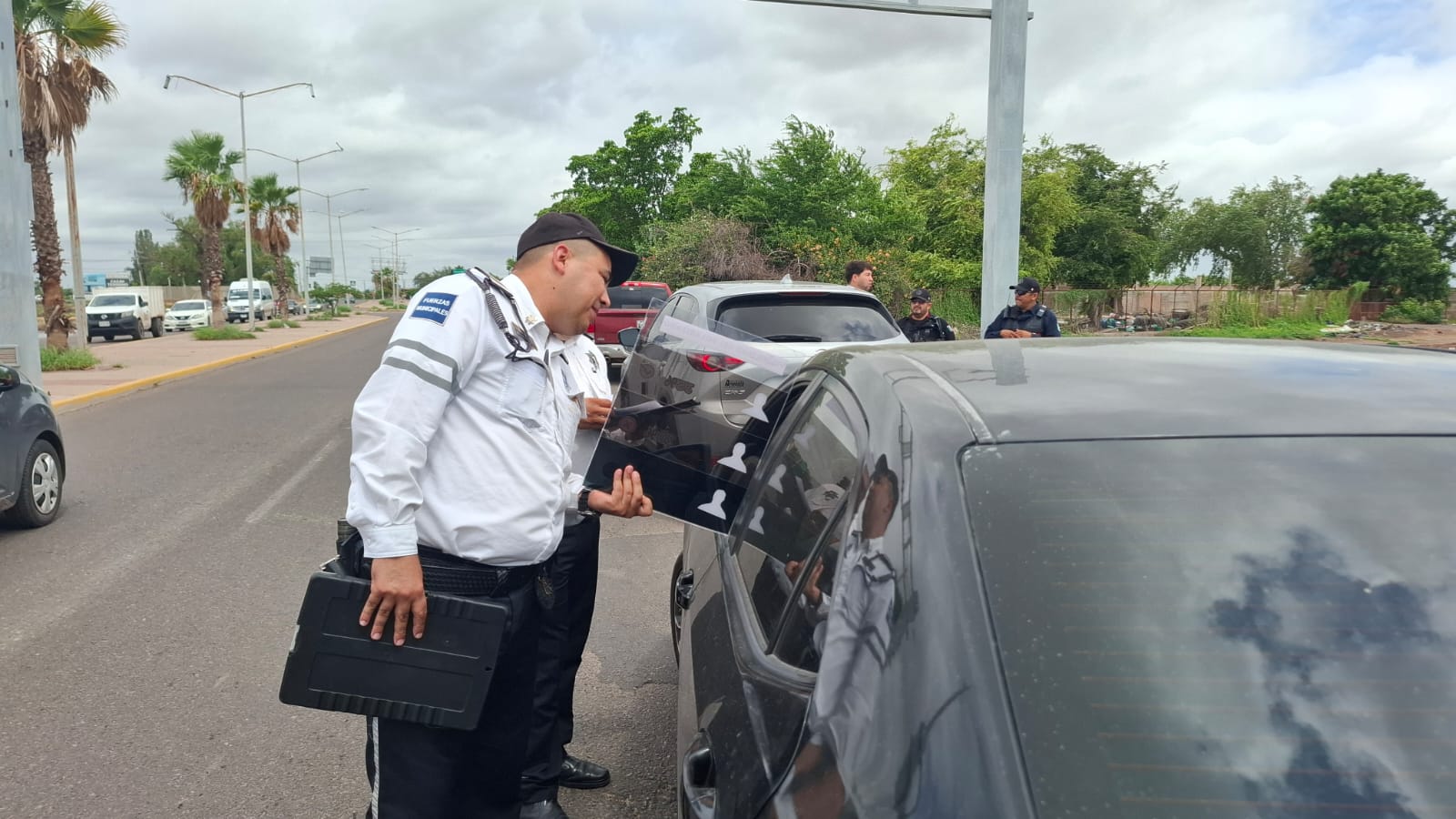 policía municipal de Ahome revisando carros polarizados