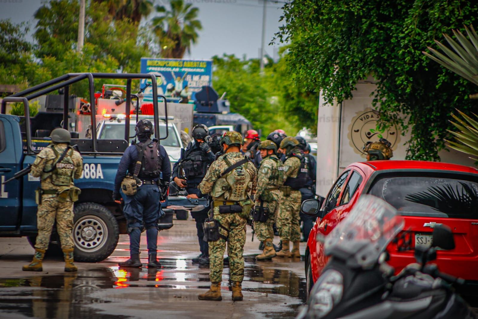 Elementos de los tres niveles de gobierno resguardan el lugar donde un policía estatal fue asesinado en Culiacán
