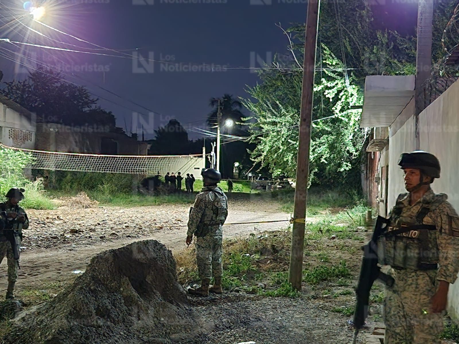 Elementos de seguridad resguardan el lugar donde un hombre fue encontrado ejecutado en Culiacán