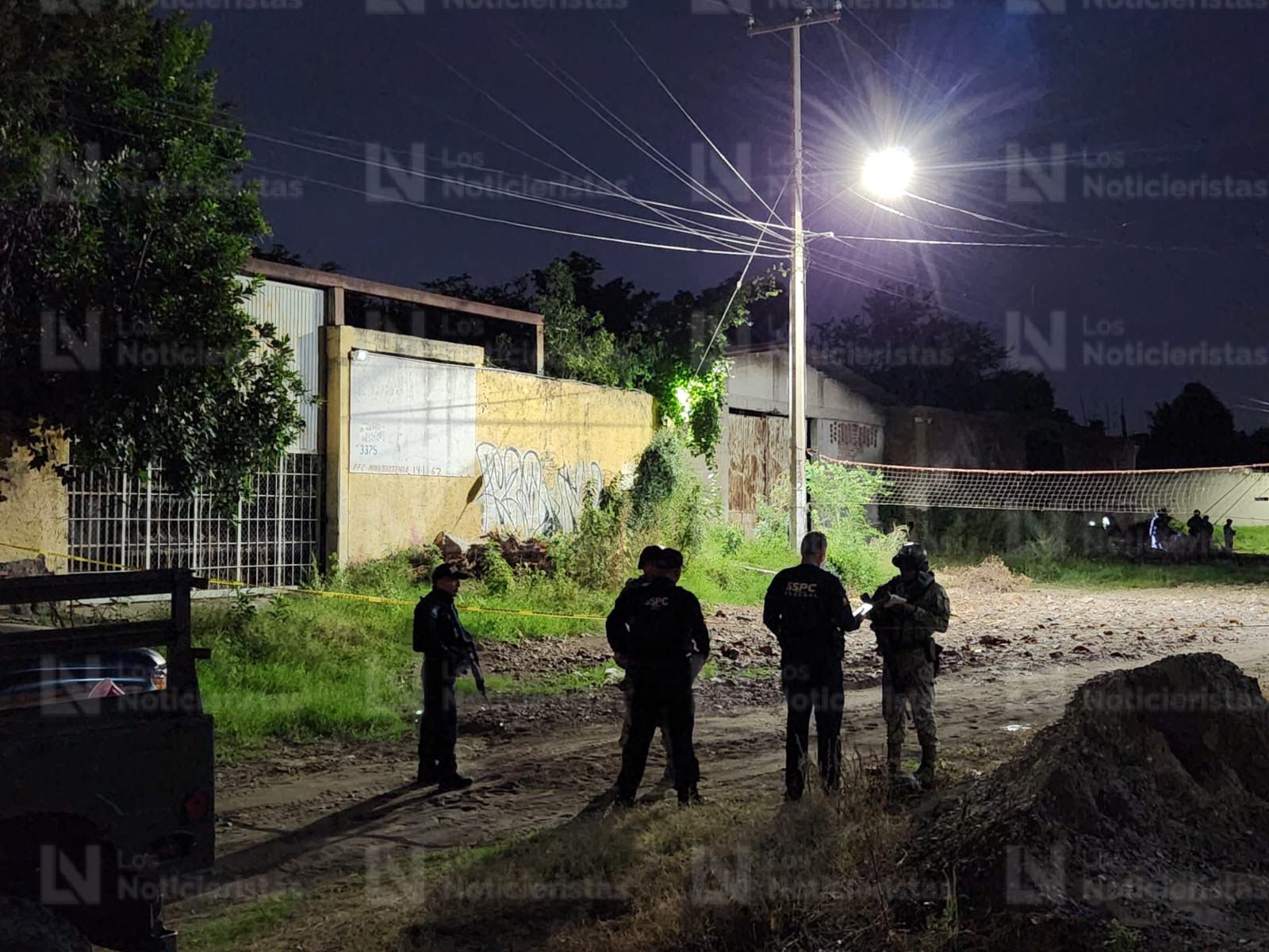 Elementos de seguridad resguardan el lugar donde un hombre fue encontrado ejecutado en Culiacán