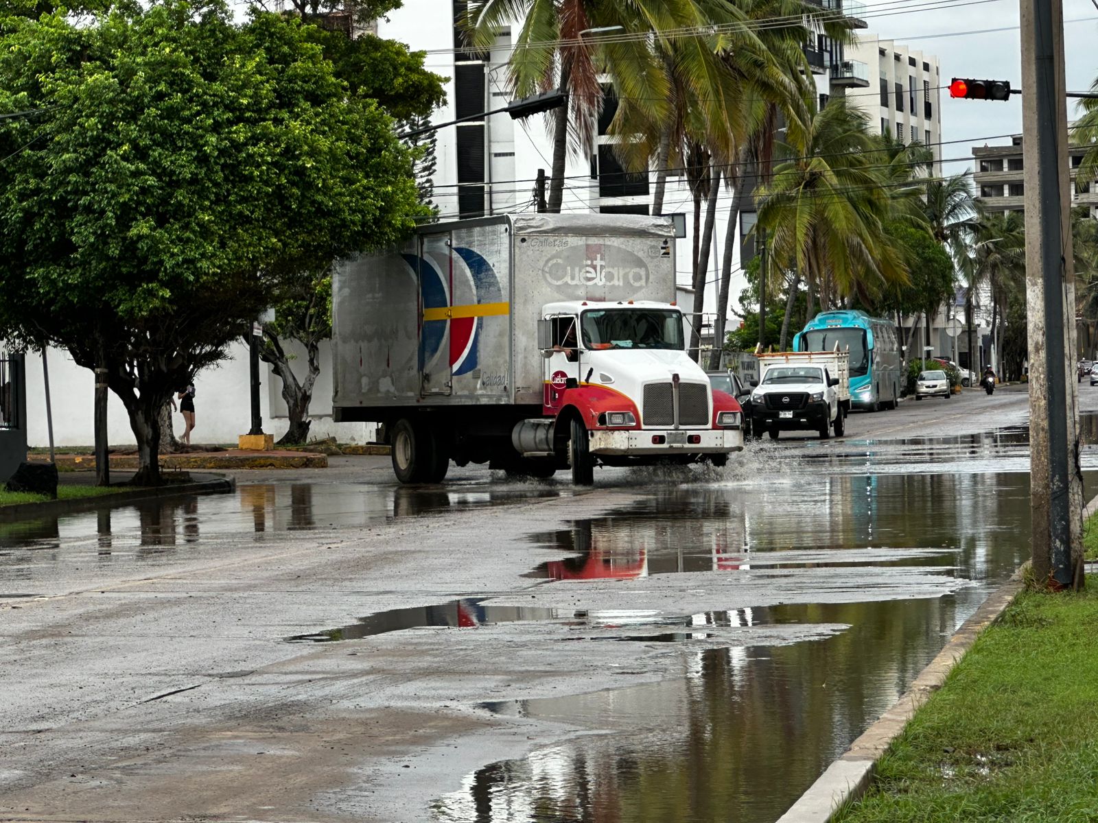 Vehículos circulando por calles mojadas tras lluvias de Mazatlán