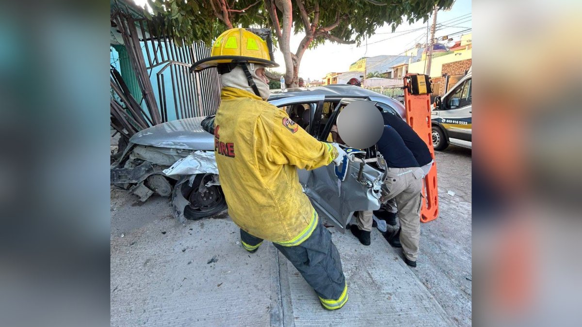 Bomberos rescatando a victimas de vehículo accidentado