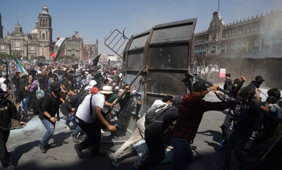 Encapuchados tirando vallas en la marcha de la Generación Z