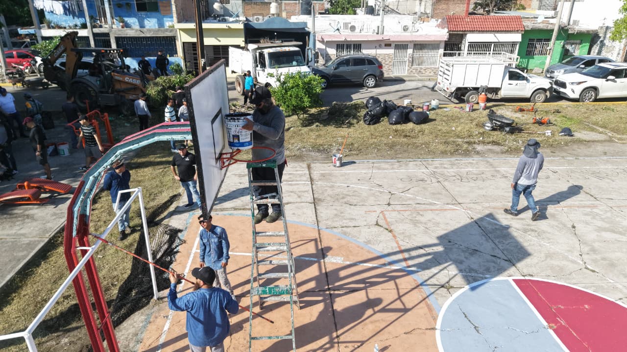persona pintando tablero de basquetbol en parque