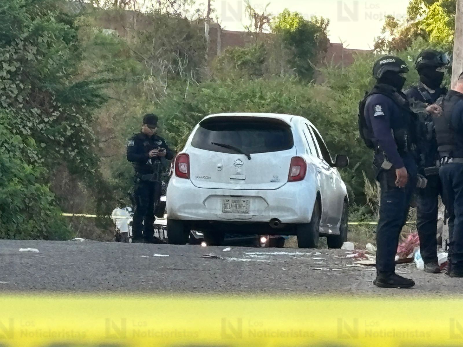 Elementos policíacos resguardan el vehículo del conductor de plataforma tras ataque armado