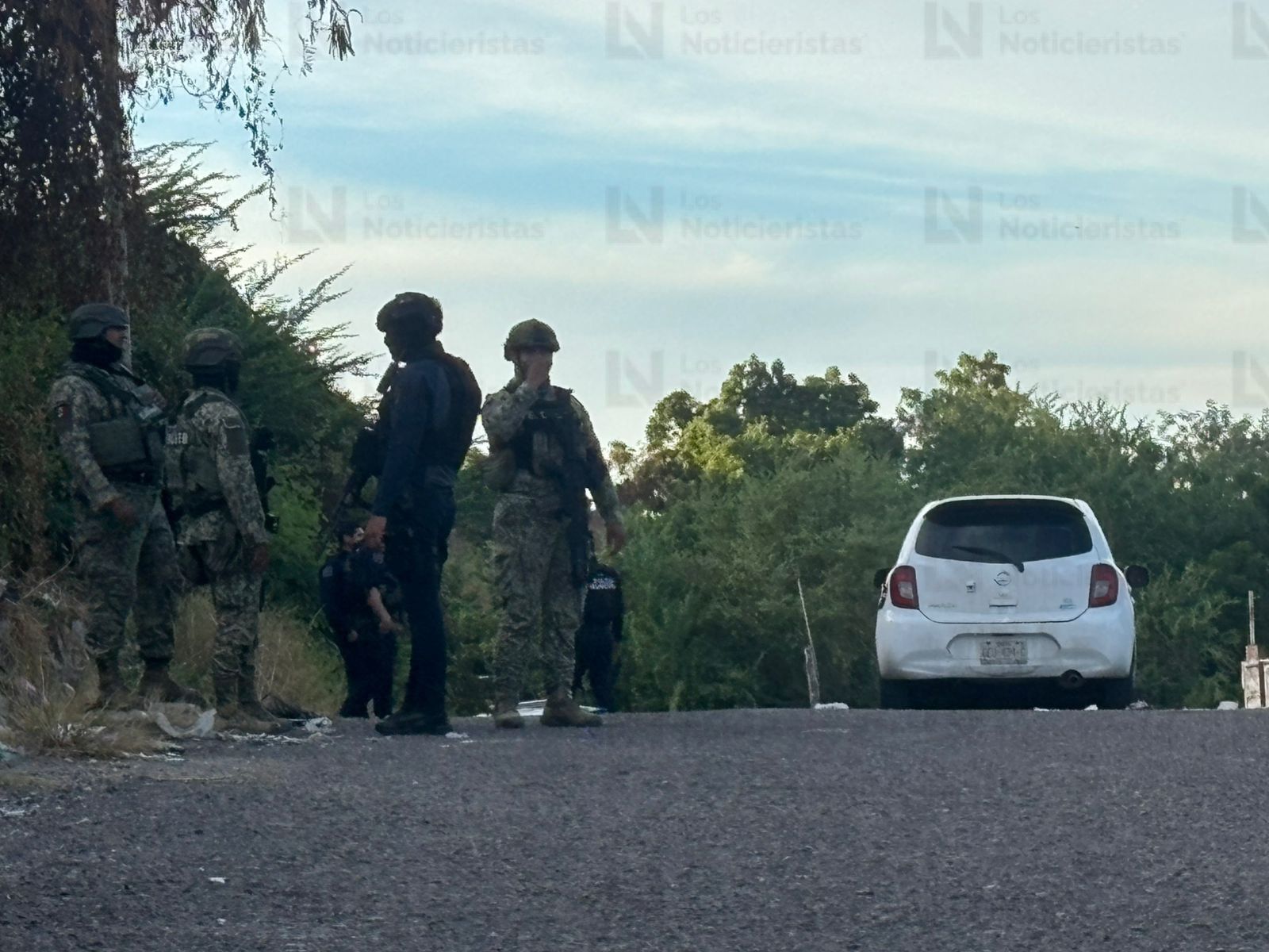 Elementos policíacos resguardan el vehículo del conductor de plataforma tras ataque armado
