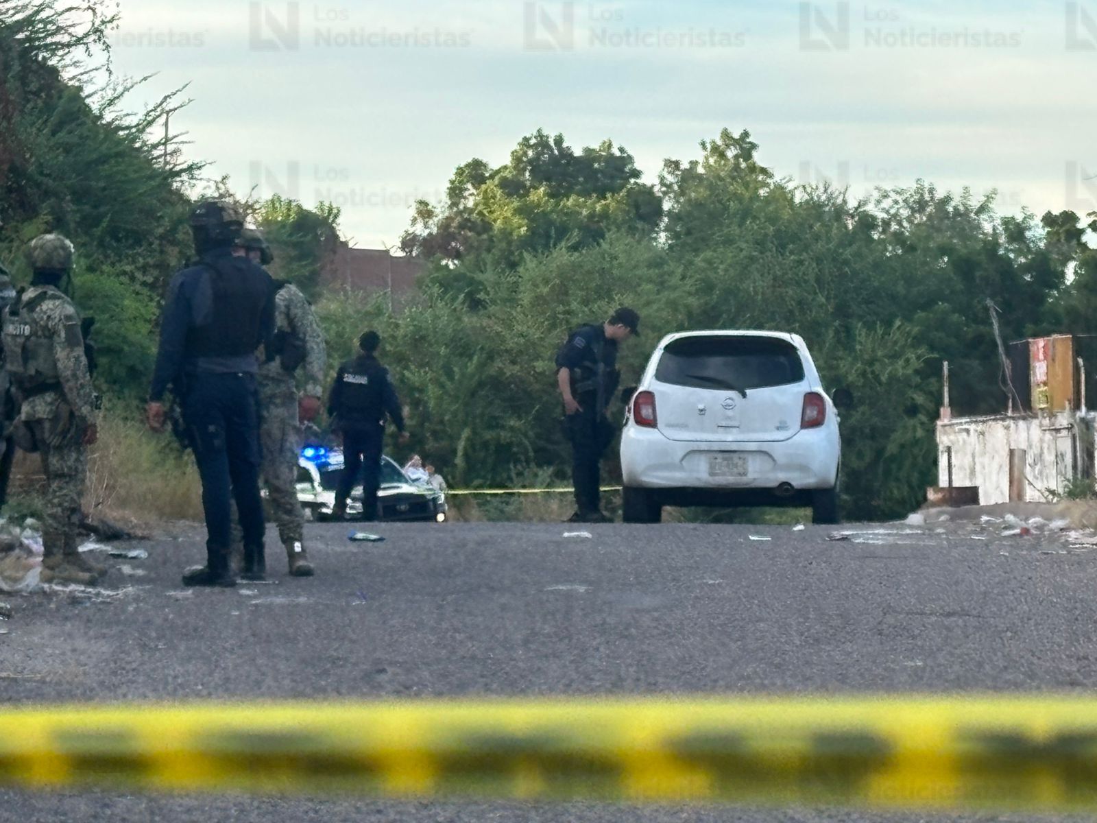 Elementos policíacos resguardan el vehículo del conductor de plataforma tras ataque armado