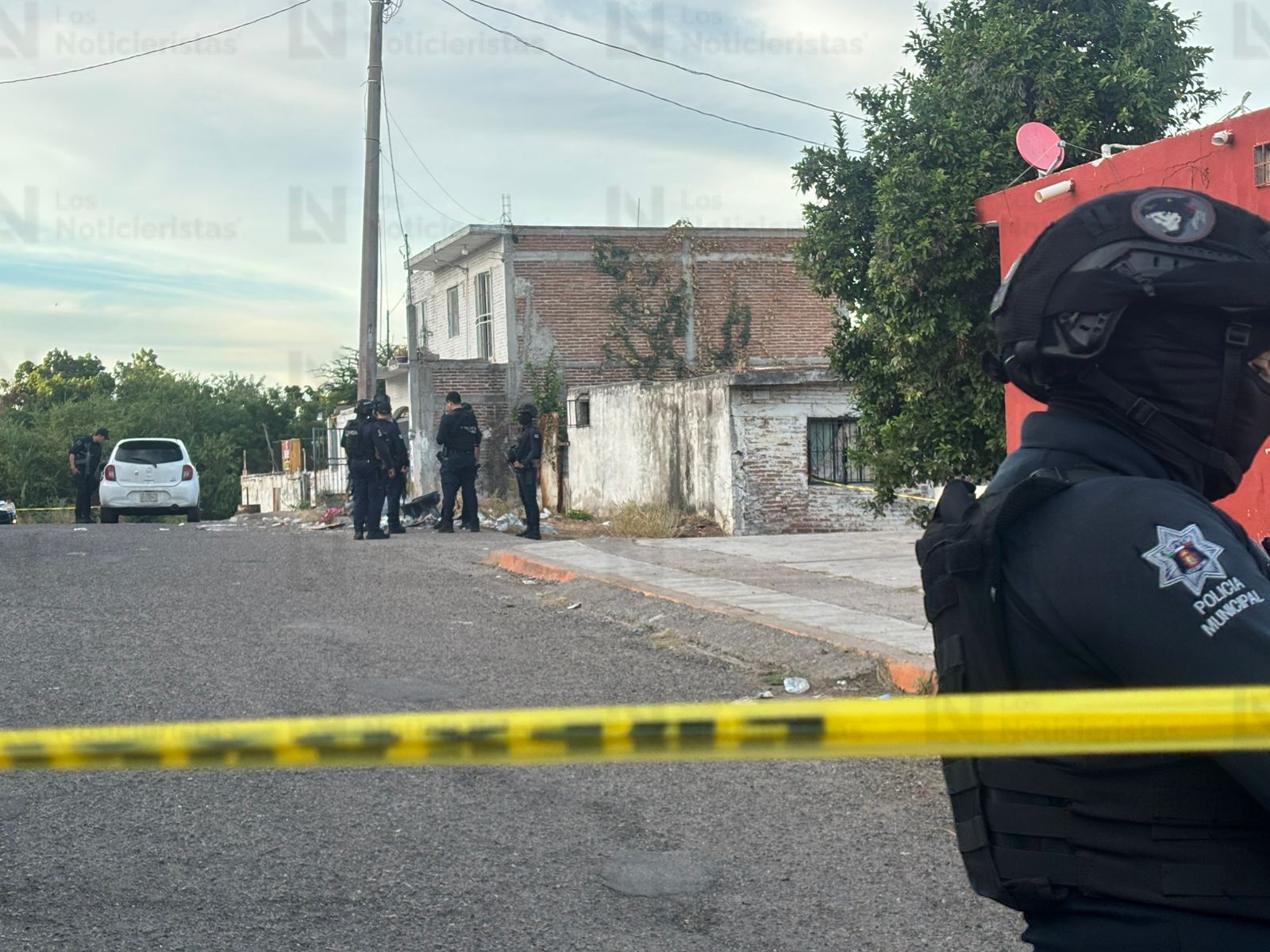 Elementos policíacos resguardan el vehículo del conductor de plataforma tras ataque armado