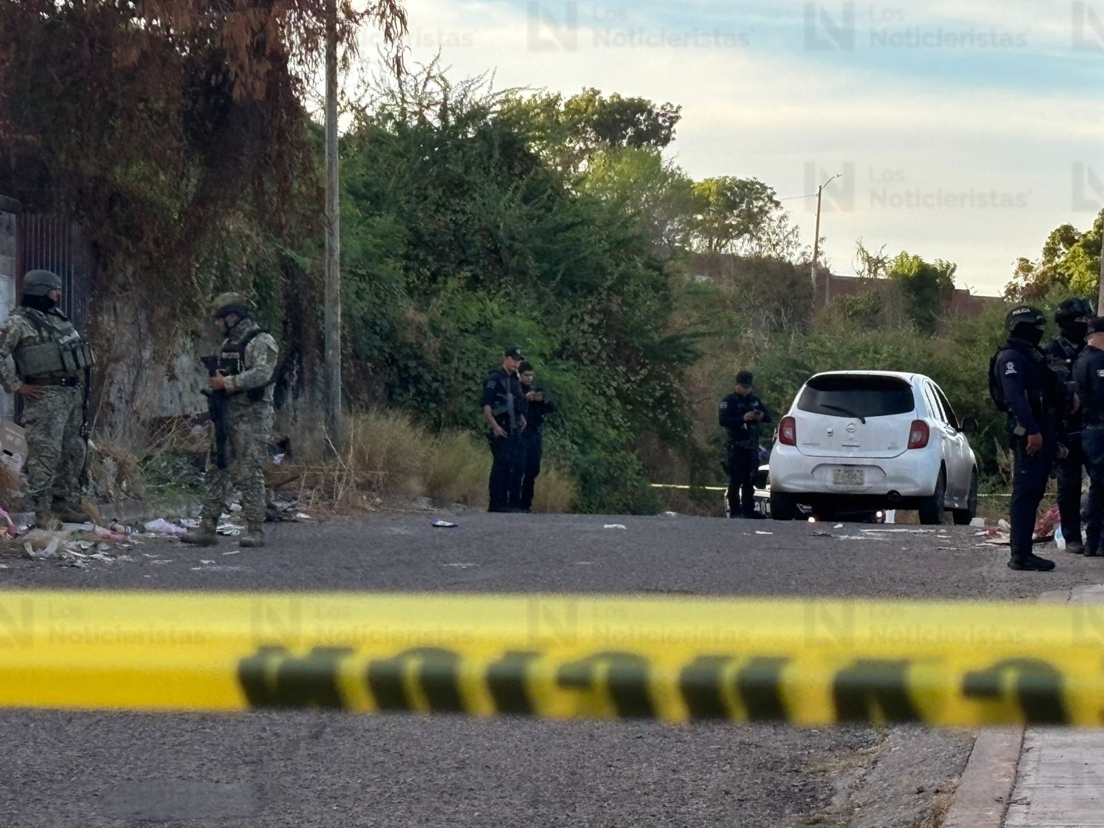 Elementos policíacos resguardan el vehículo del conductor de plataforma tras ataque armado