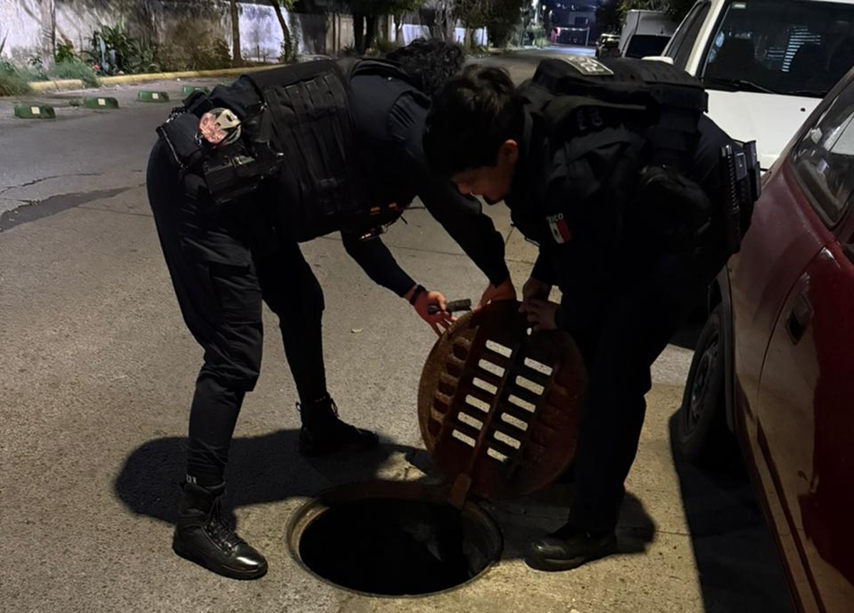 Policías checando una alcantarilla