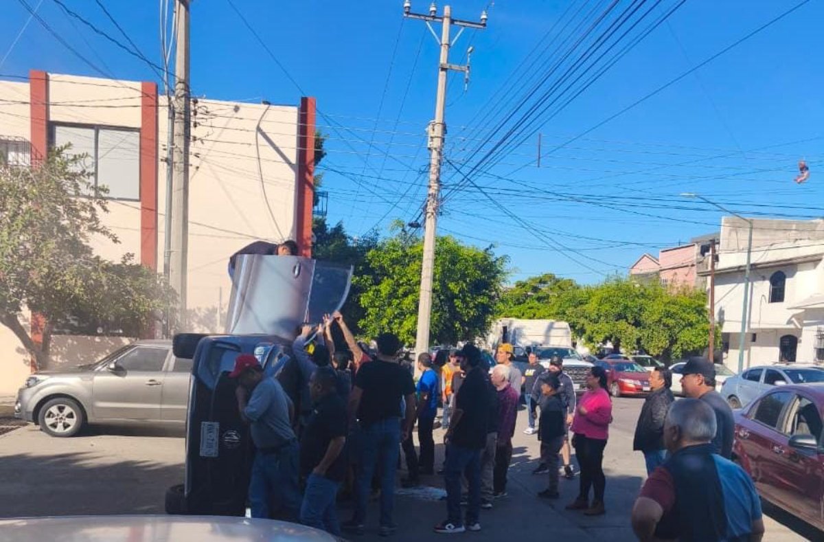 camioneta tipo SUV color azul metálico volcada