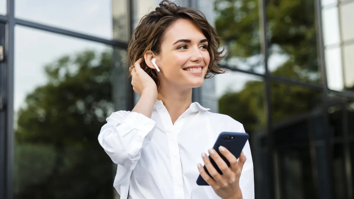 Mujer escuchando con audífonos en su celular