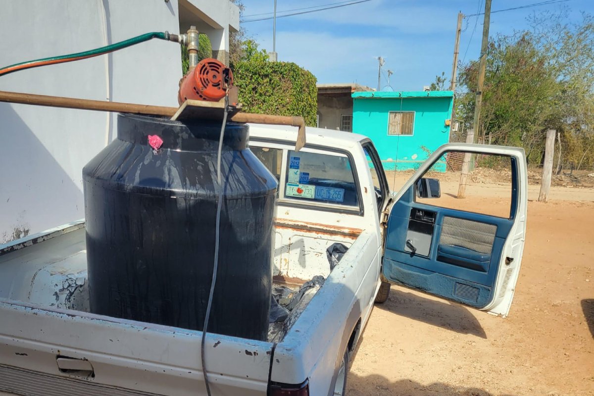 Camioneta con tinaco de agua en la caja