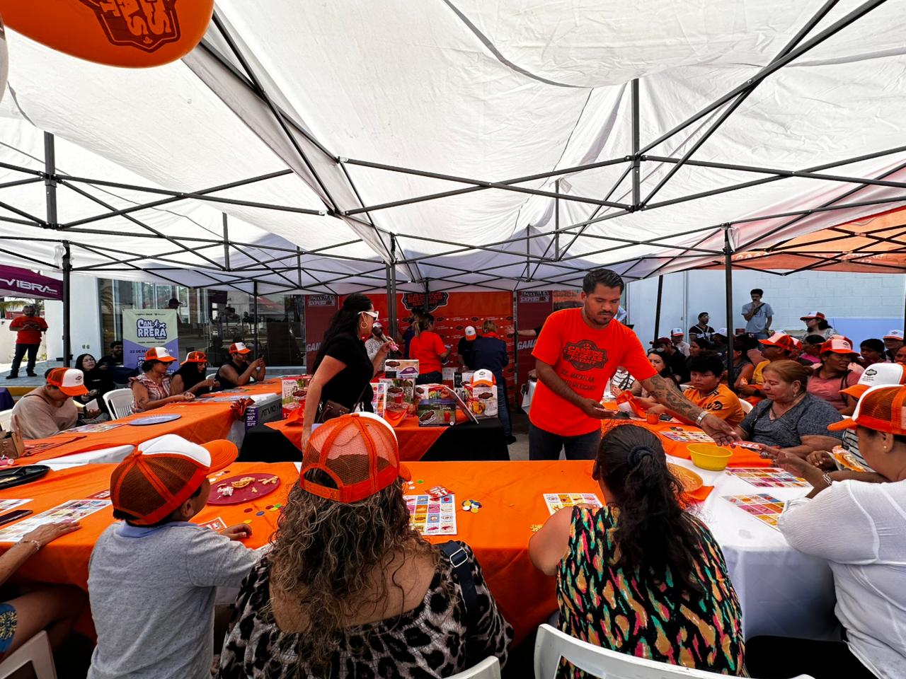 Juegan lotería afuera de sucursal de Carnes Selectas Nayarit, en Mazatlán, previo a su inauguración