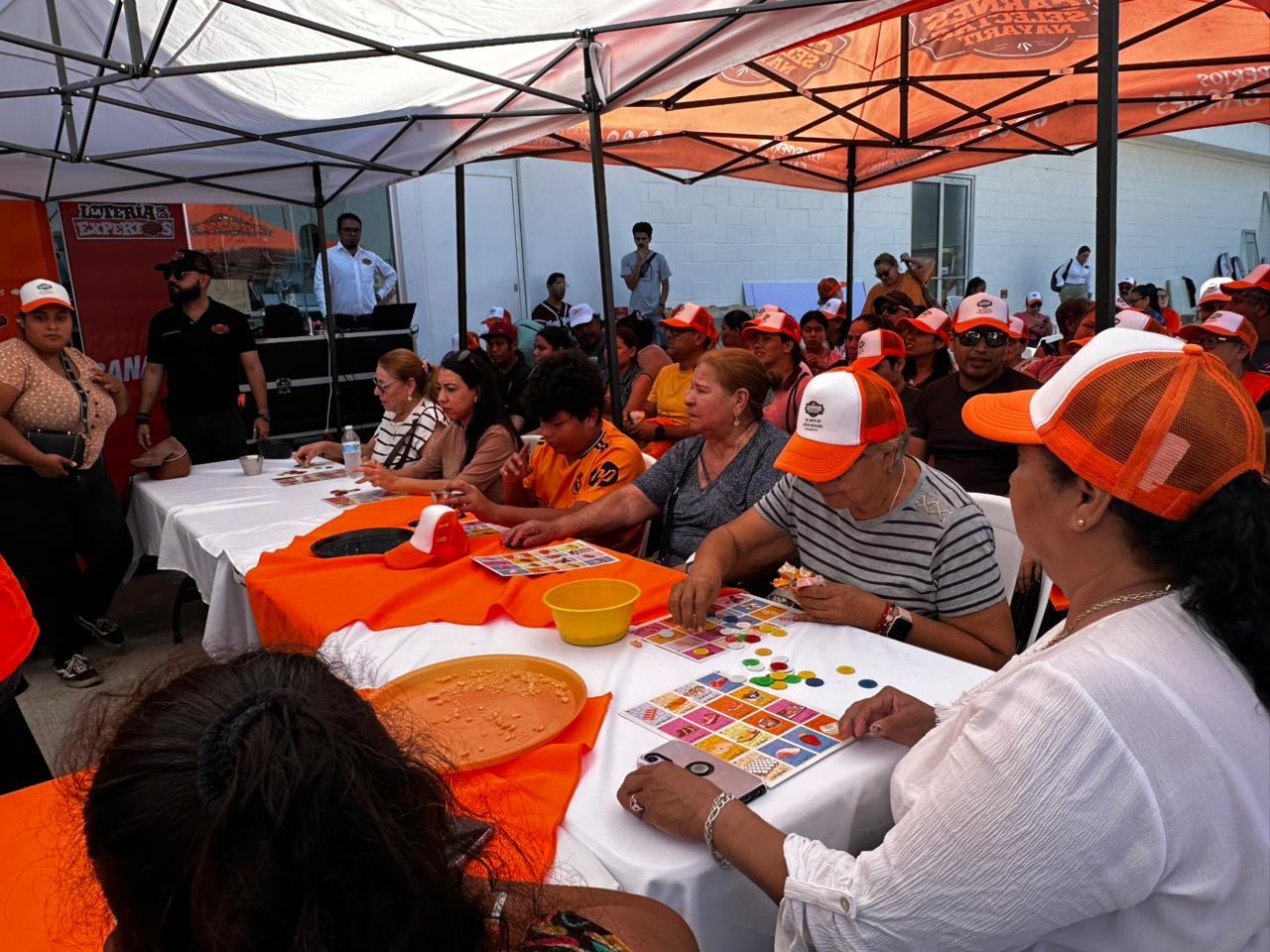 Juegan lotería afuera de sucursal de Carnes Selectas Nayarit, en Mazatlán, previo a su inauguración