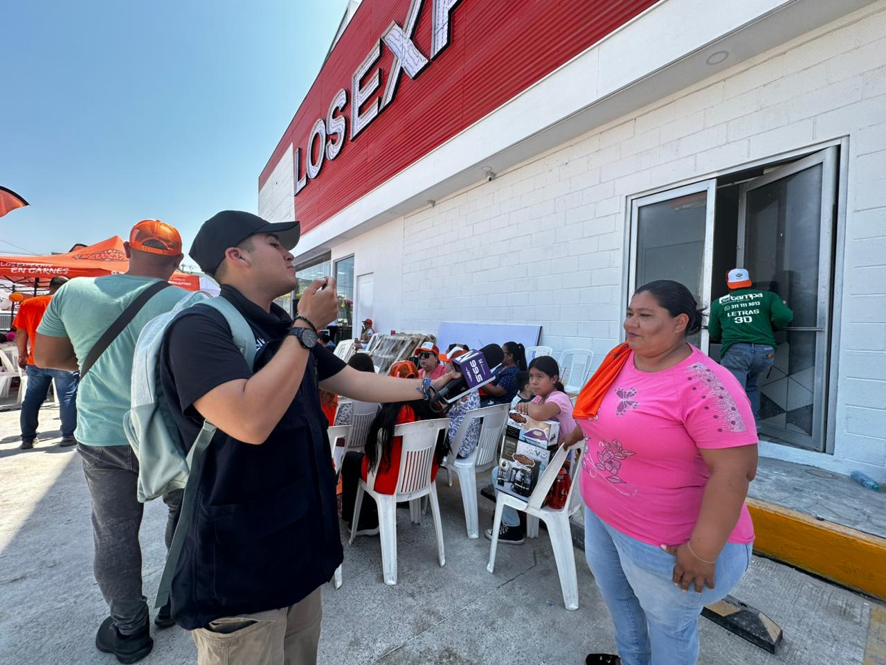 Juegan lotería afuera de sucursal de Carnes Selectas Nayarit, en Mazatlán, previo a su inauguración